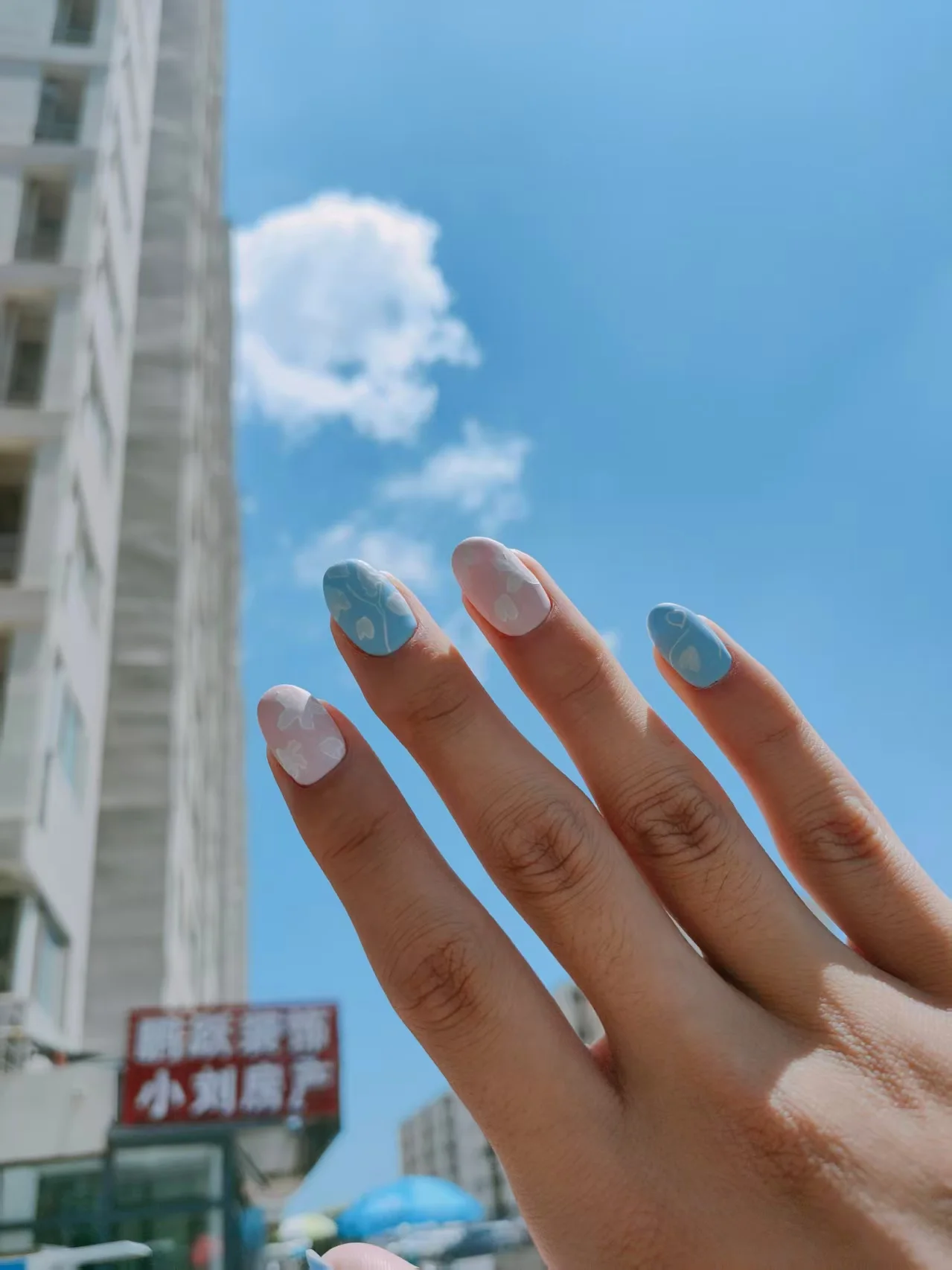 蓝天背景下的蓝白配色手绘美甲